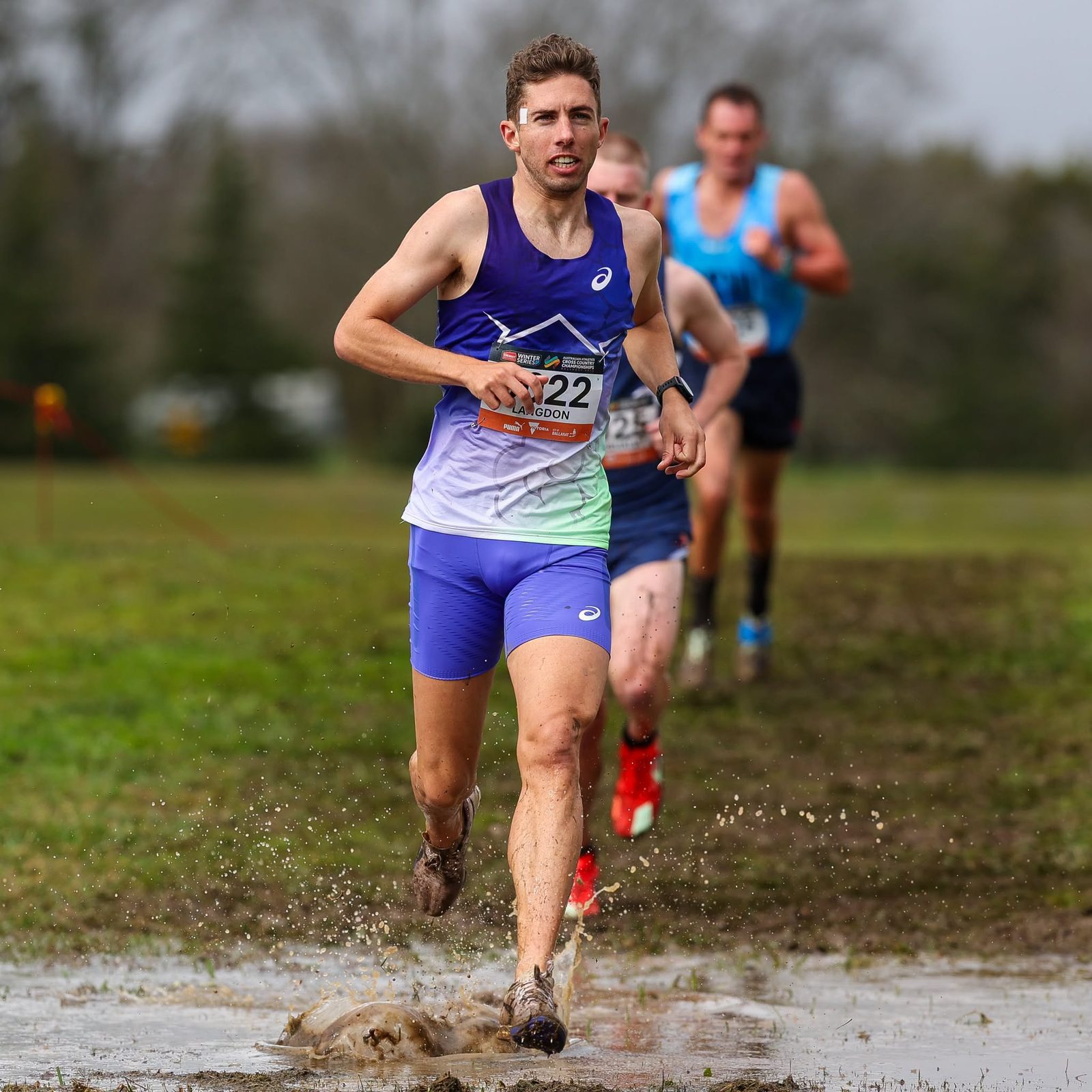 Reece Langdon running through floodwater at the Australian Cross Country Championships in Ballarat