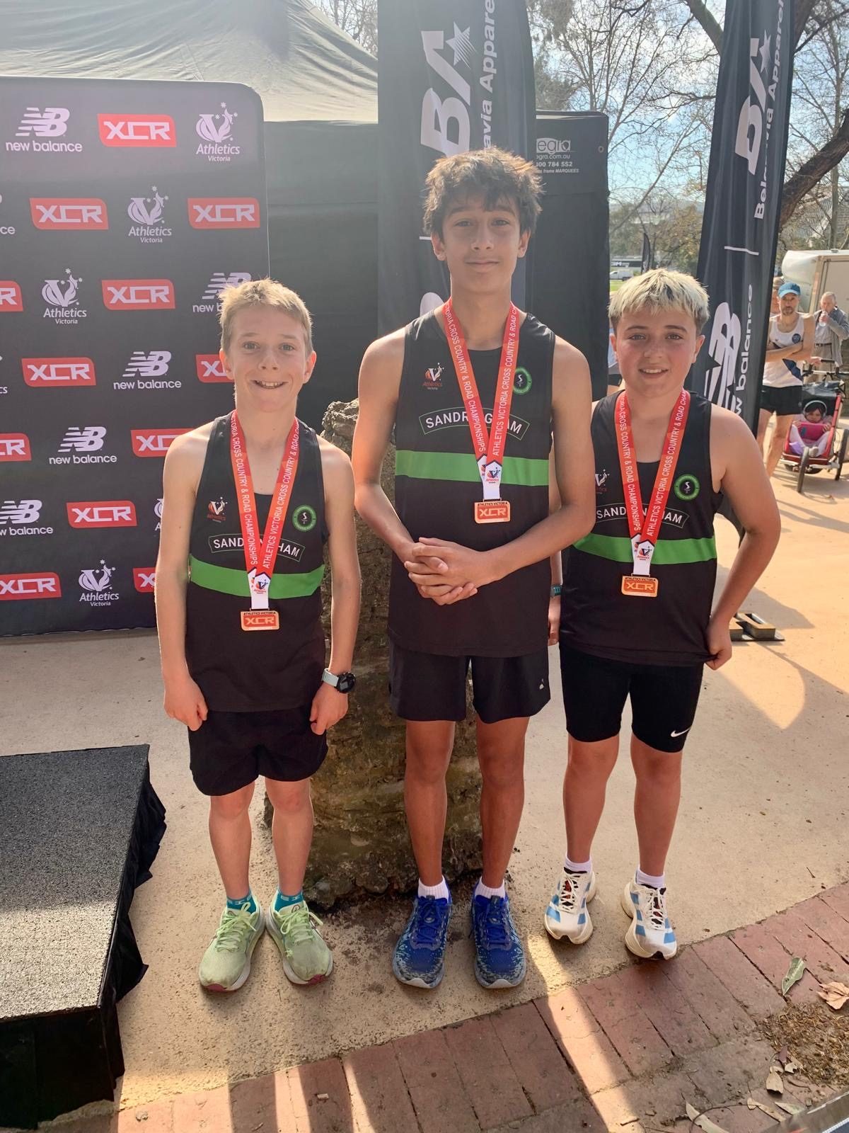 Three Sandringham junior boys wearing their medals at the Tan Relays